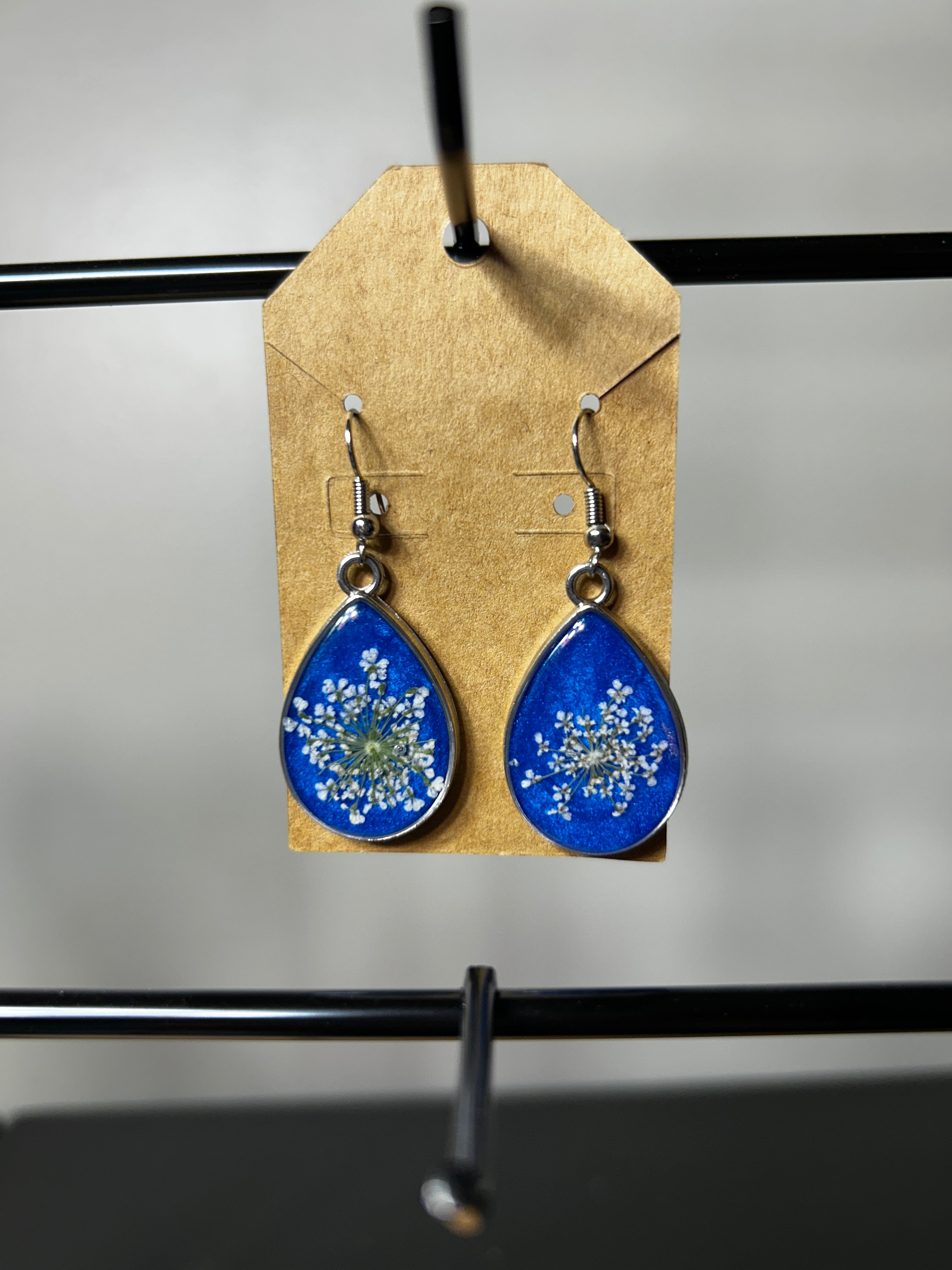 Queen Anne's lace pressed flower cobalt blue resin teardrop earrings with silver bezel on kraft card display