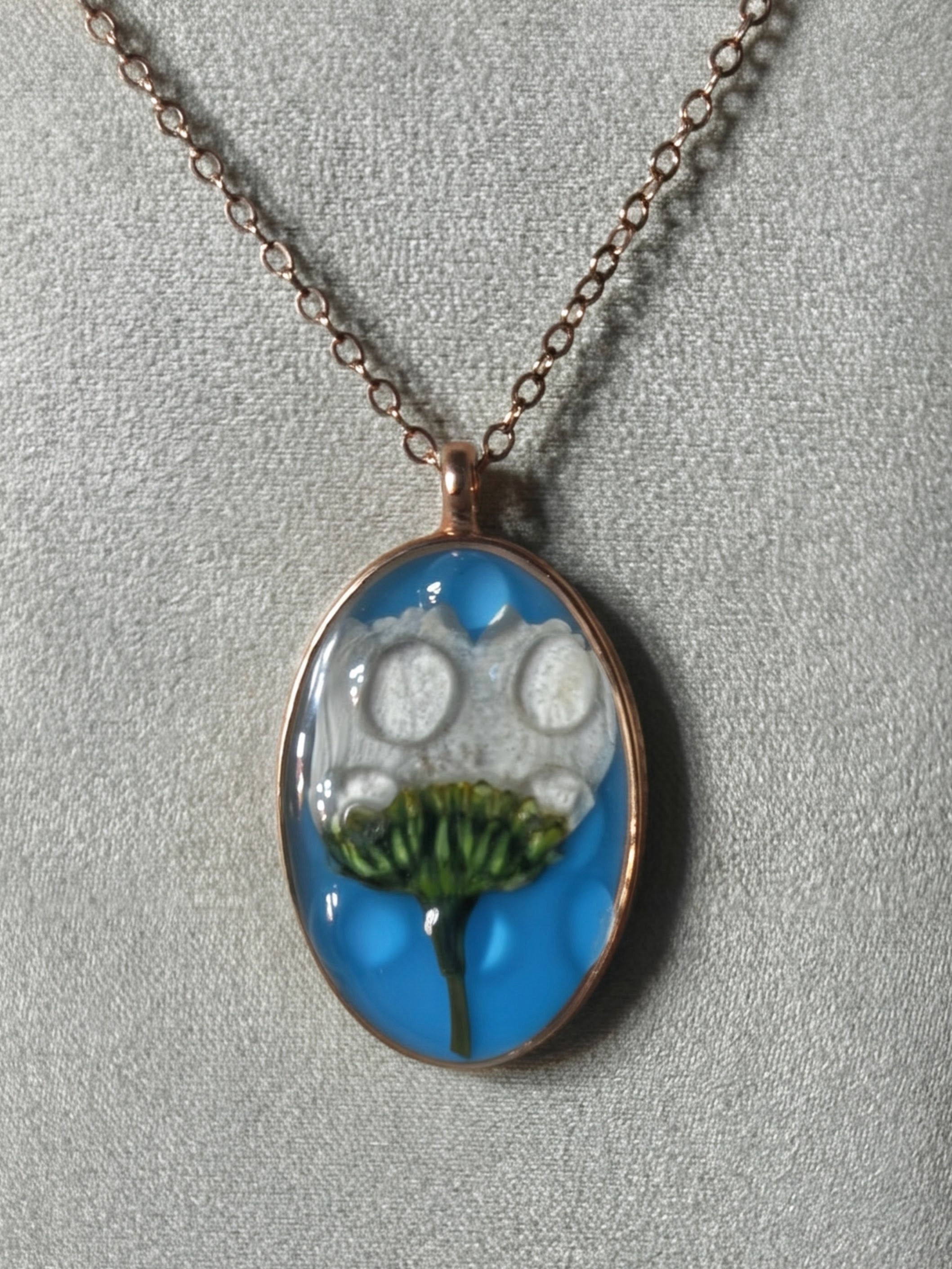 White Queen Anne's lace flower with green stem in sky blue resin oval pendant with rose gold bezel on rose gold chain